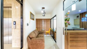 A modern interior with a sofa, a dining table, and a kitchen area. - The Topaz Residence (Phuket)