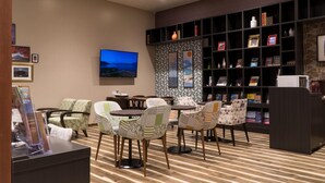 A library with bookshelves, a television, and seating areas. - Cabin & Lounge Highland Station Inn (Fujikawaguchiko)