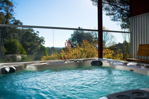A hot tub with a clear view of trees and a wooden deck. - Artemis Retreat (Daylesford)
