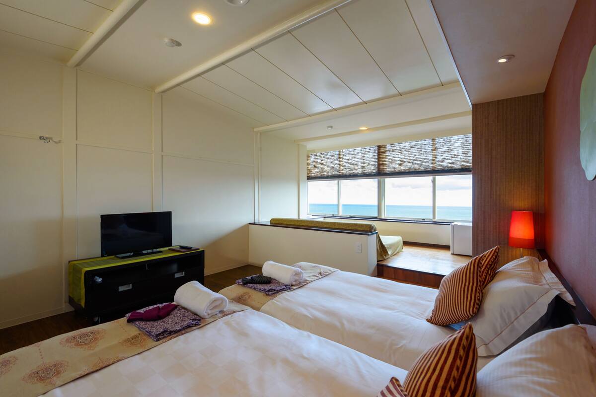 Chambre avec lits jumeaux, salle de bains commune, vue mer