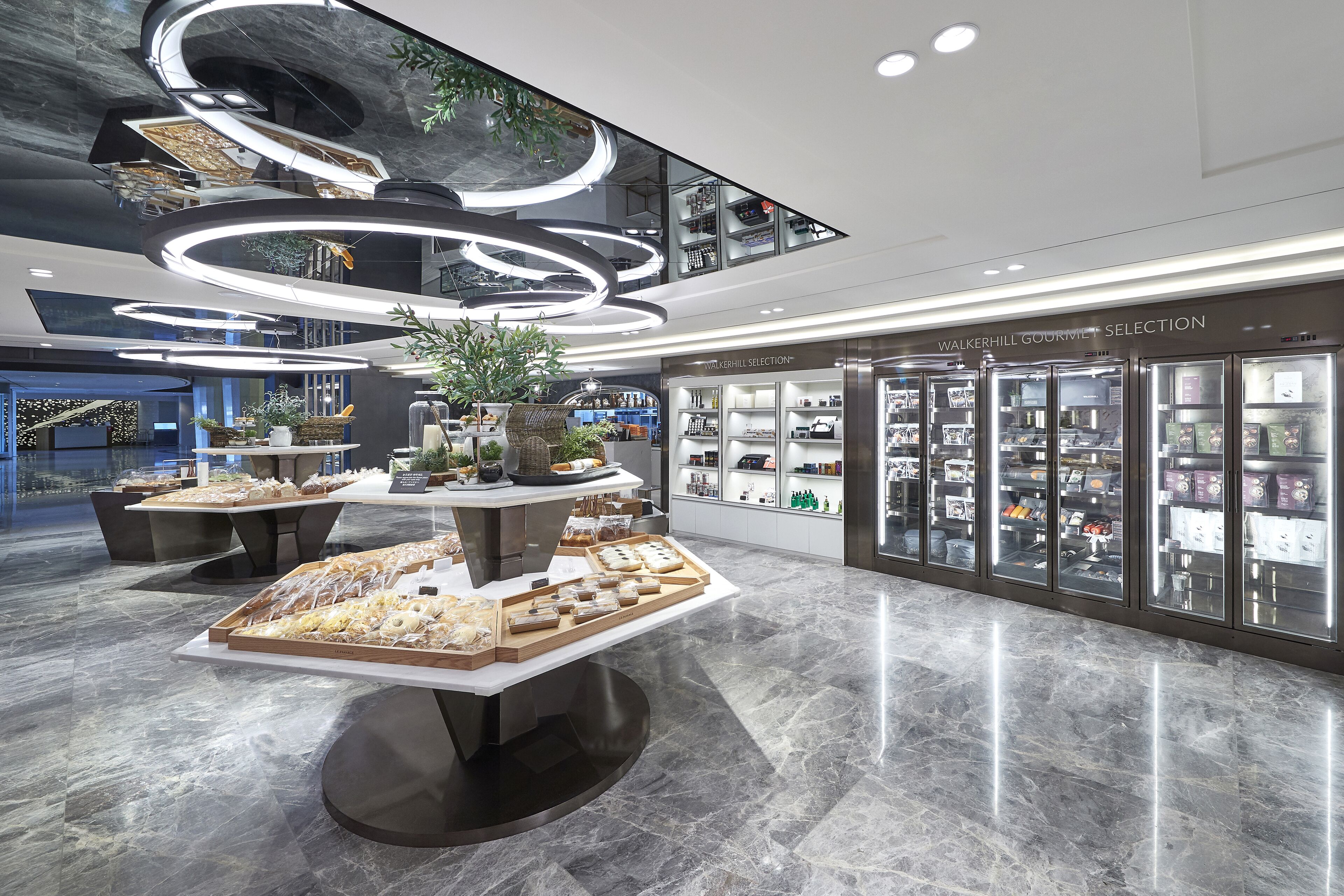 A modern interior with a central display of food items, a walkway, and a store named "Walkhill Gourmet Selection".