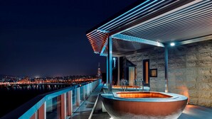 Un área moderna de hidromasaje al aire libre con vistas a la ciudad de noche.