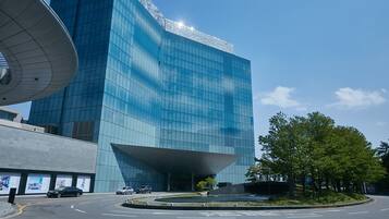 A modern building with a curved glass facade and a large overhang.