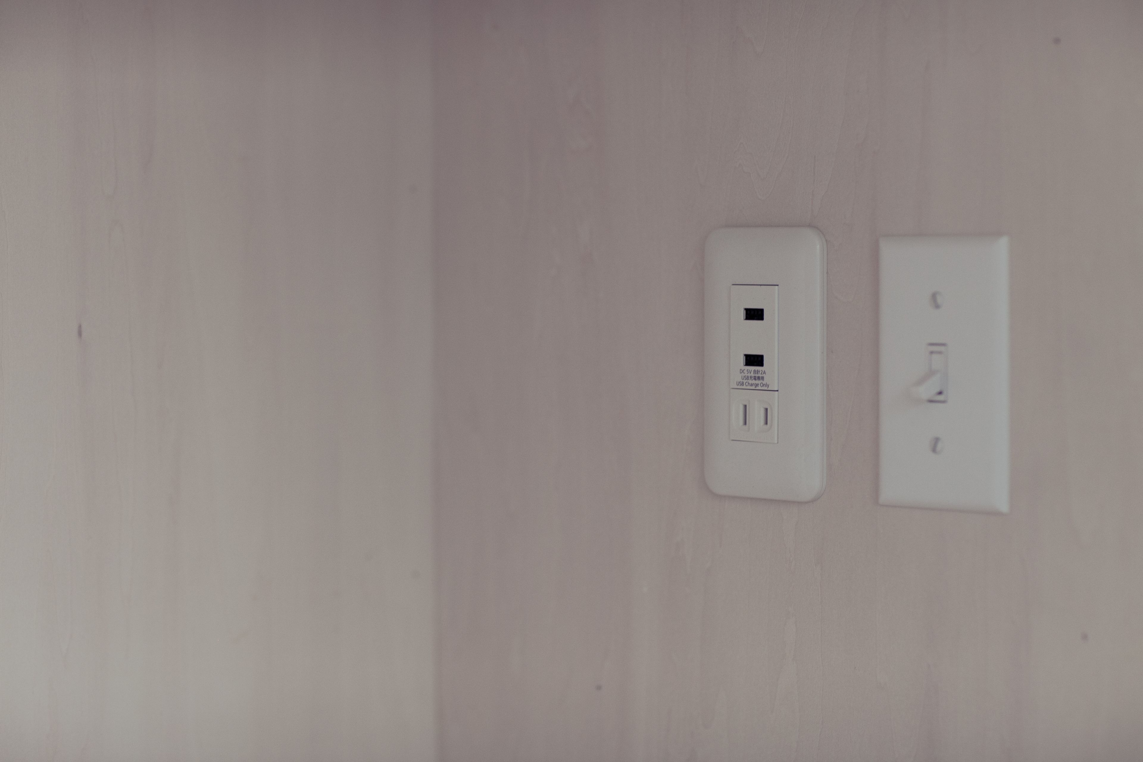 A wall with two electrical outlets and a switch.