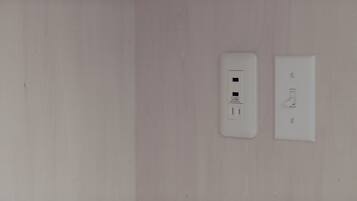 A wall with two electrical outlets and a switch.