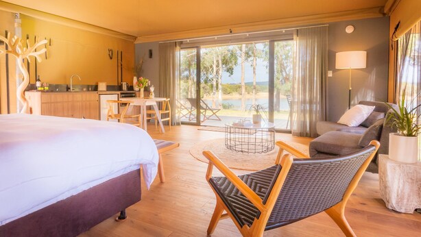 Une chambre d’hôtel comprenant un lit, un coin repas, un canapé et une vue sur l’extérieur.