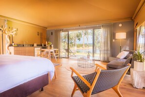 A hotel room with a bed, a dining area, a sofa, and a view of the outdoors. - Olio Bello Lakeside Glamping (Cowaramup)