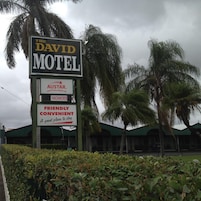 Letrero de motel con la marca 'DAVID MOTEL' y 'AUSTAR', que indica habitaciones disponibles y un servicio de reservas.