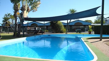 Una piscina al aire libre, sombrillas, tumbonas