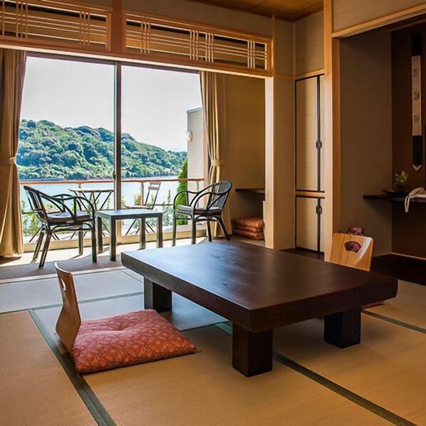 A traditional Japanese room with tatami flooring, a low table, and chairs. - Ryokan Nakashimaso (Kamiamakusa)