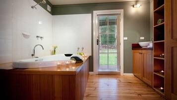 A bathroom with a wooden vanity, a bathtub, and a shower.