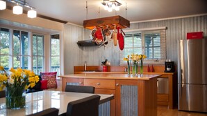 A modern kitchen with a central island, wooden cabinetry, and a stainless steel refrigerator. - Finlie (Hepburn)
