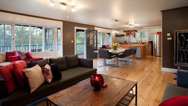 A modern living room with a sofa, coffee table, and dining area. - Finlie (Hepburn)