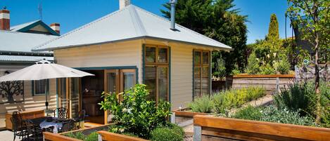 A house with a patio area featuring wooden planters and outdoor furniture.