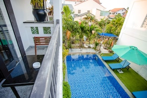 A balcony with a glass door, a small table, and a bench. - Trendy Life Villa Hoi An (Da Nang)