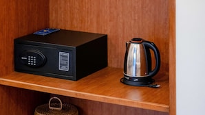 A wooden shelf with a black electronic device and a silver kettle. - Trendy Life Villa Hoi An (Da Nang)