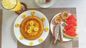 A breakfast plate with pancakes, bananas, and passion fruit on a table. - Trendy Life Villa Hoi An (Da Nang)
