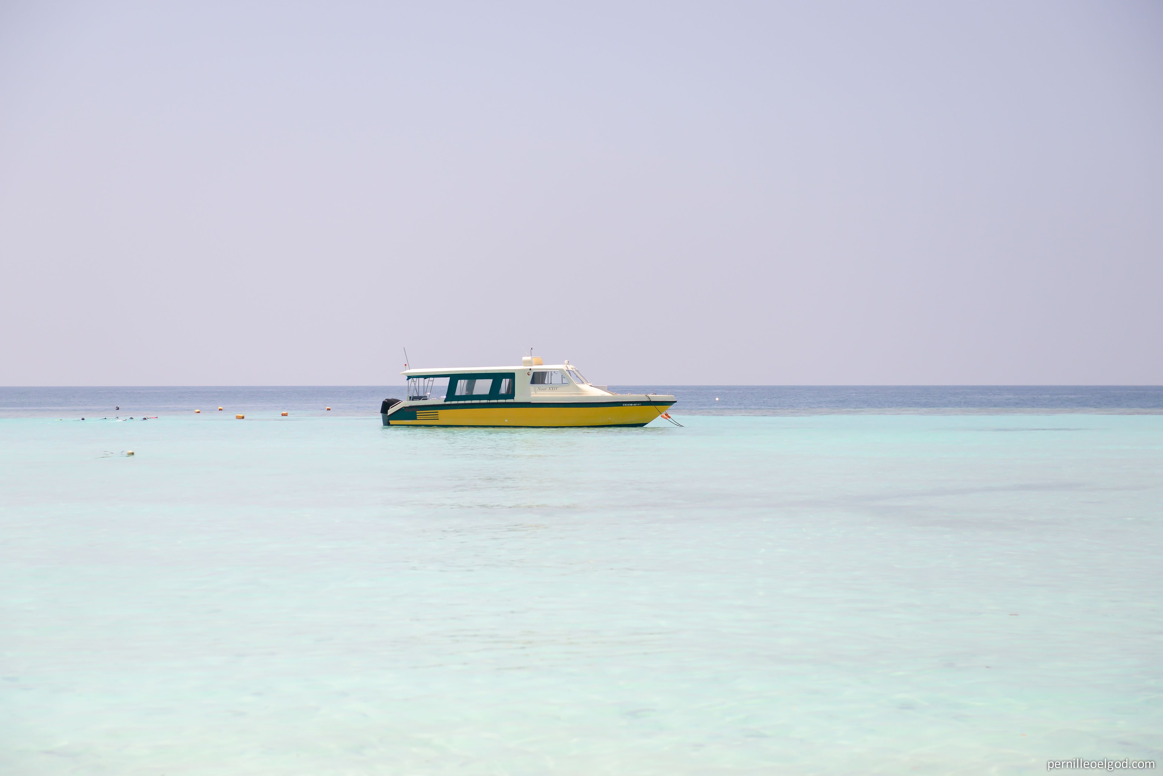 A small boat on calm turquoise water.