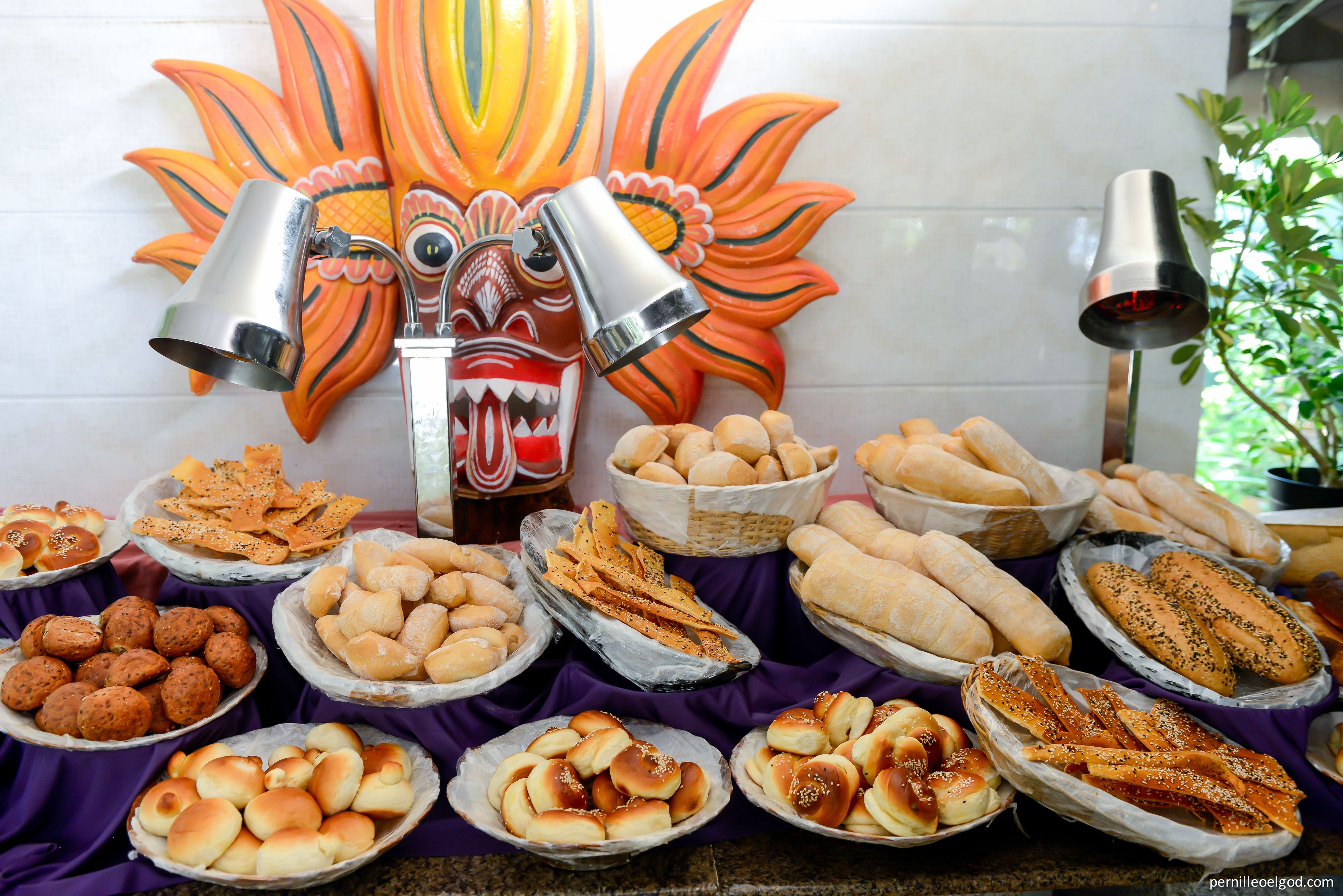 A buffet table with various breads and pastries.