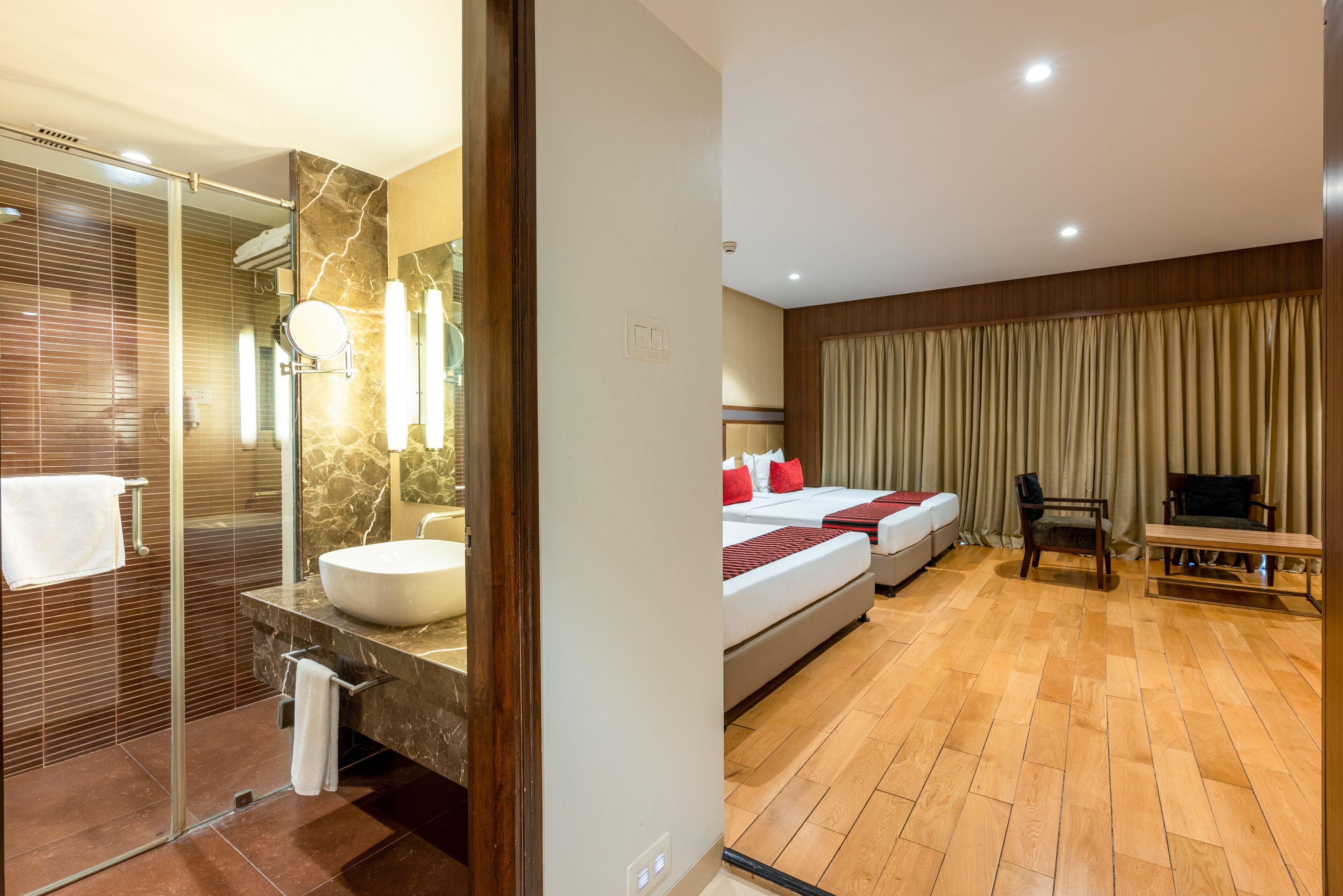 Habitación de hotel con baño, cama, televisión y zona de estar.