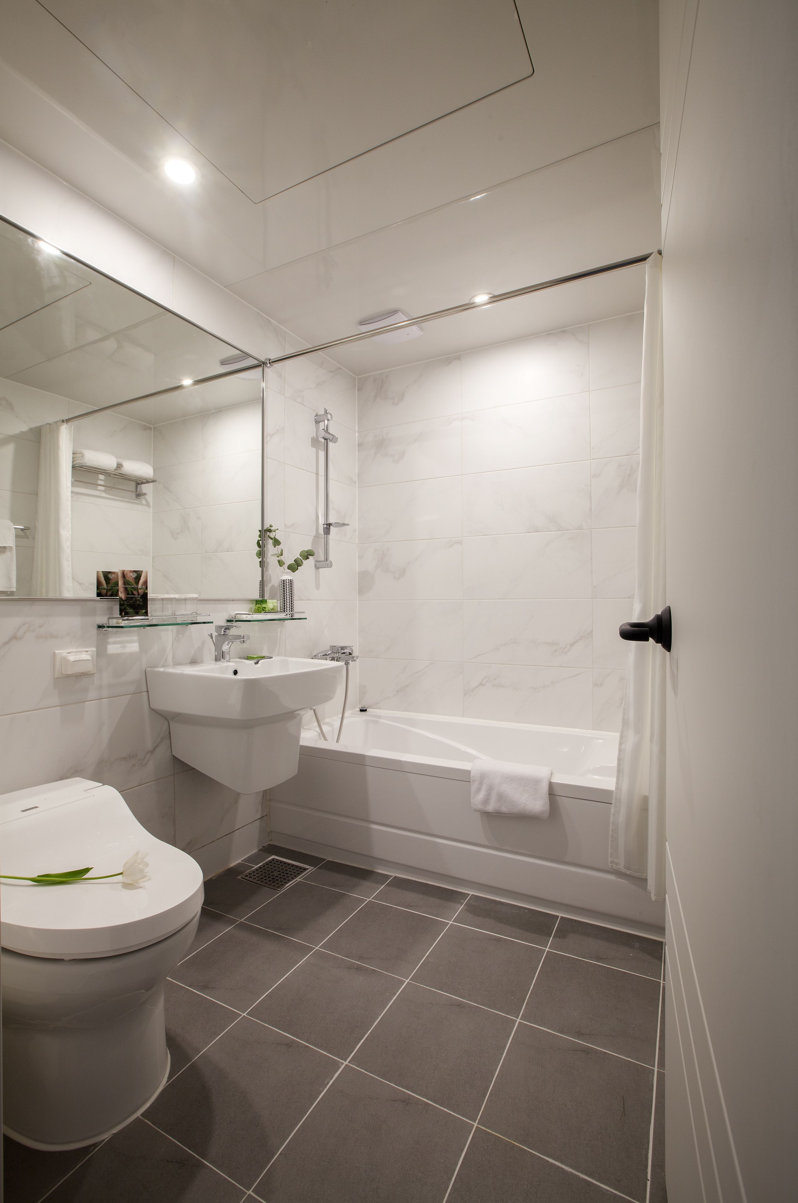 A modern bathroom with a toilet, sink, and bathtub.