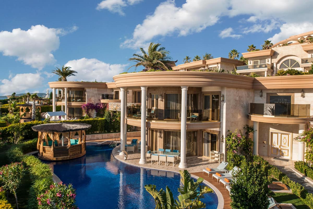 A luxurious resort with a central pool, multiple balconies, and lush landscaping.