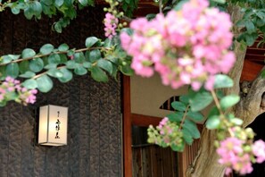 Una pared de madera con un diseño texturizado y un letrero con caracteres japoneses.
