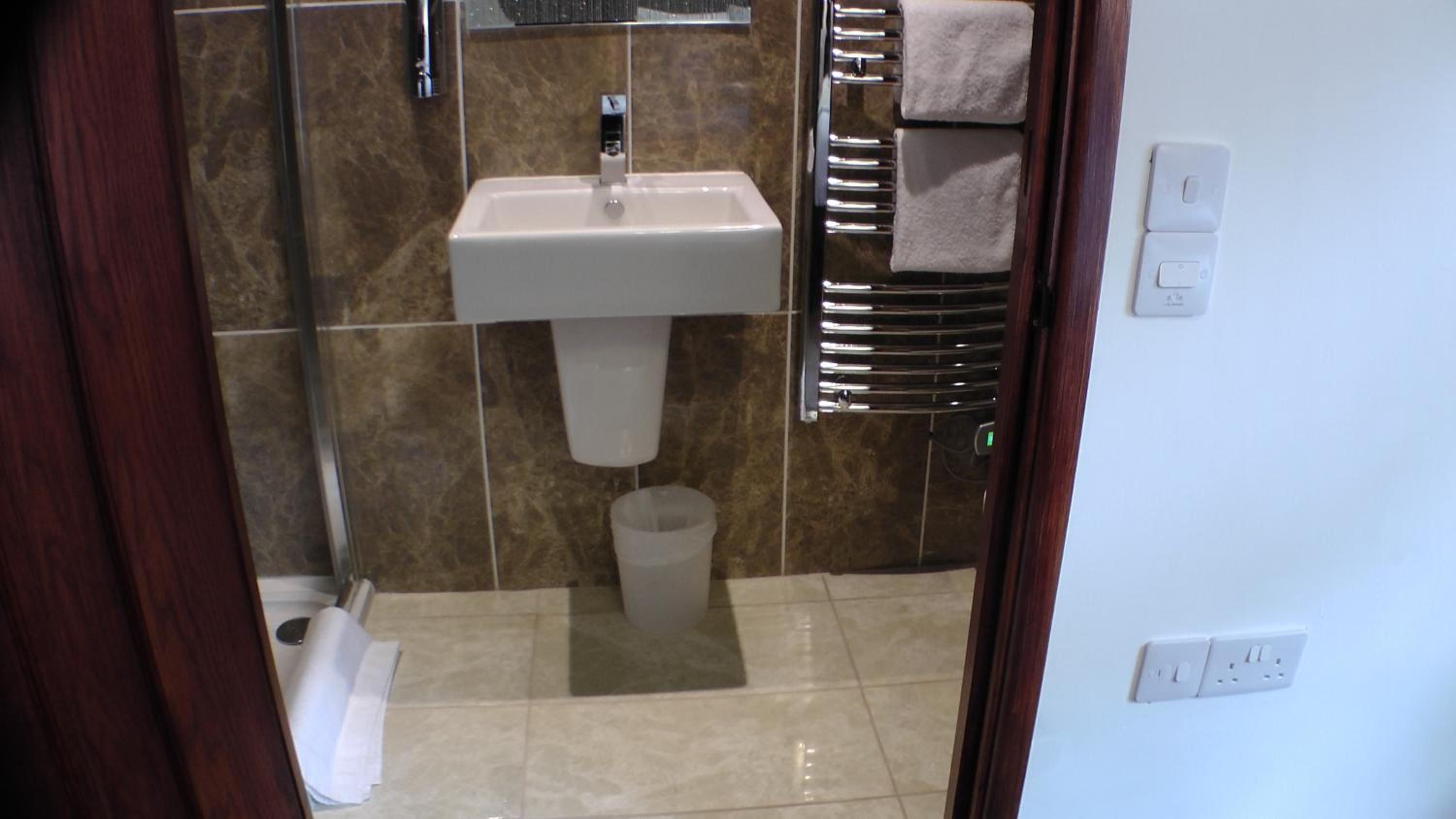 Un bagno con lavandino, specchio, portasci e water.