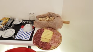 A breakfast setup with pastries, bread, cheese, and cured meats on a table. - Il Saraceno (Sorrento)