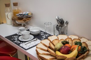 A breakfast table with bread, fruits, and a tea set. - Il Saraceno (Sorrento)