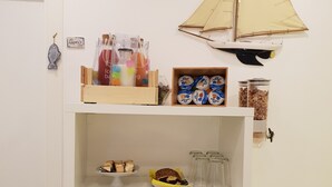 A white cabinet with a sailboat decoration, a small fish ornament, and various food items including yogurt and cookies. - Il Saraceno (Sorrento)