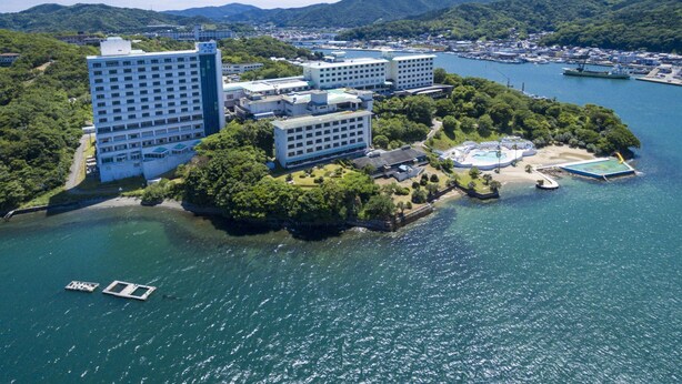 An aerial view of a coastal hotel complex with multiple buildings, a swimming pool, and a dock. - Toba Seaside Hotel (Toba)