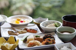 A variety of dishes on a table, including sushi, sashimi, and other Asian cuisine. - Toba Seaside Hotel (Toba)