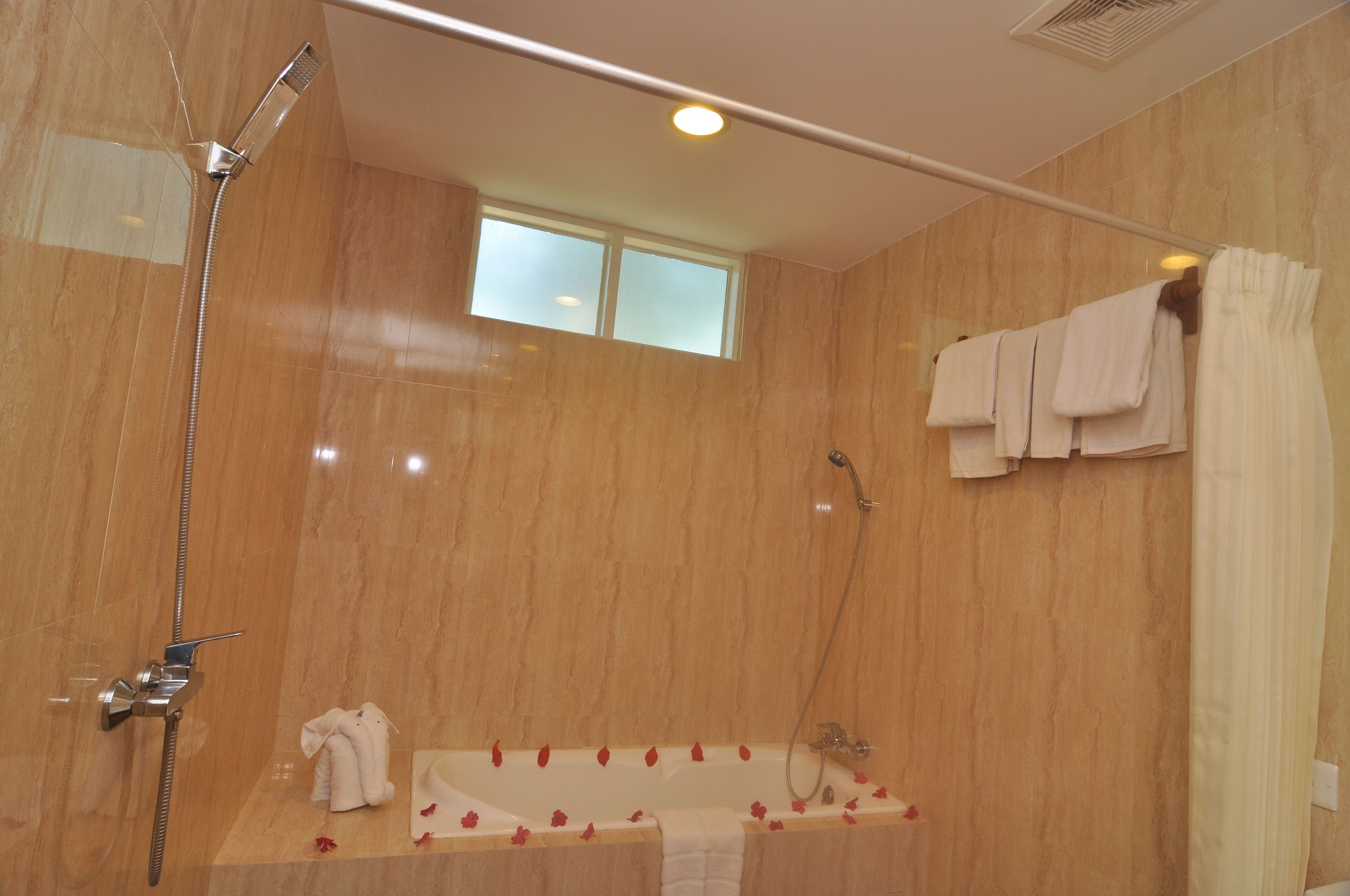 Ein Badezimmer mit Badewanne, Dusche und Fenster.