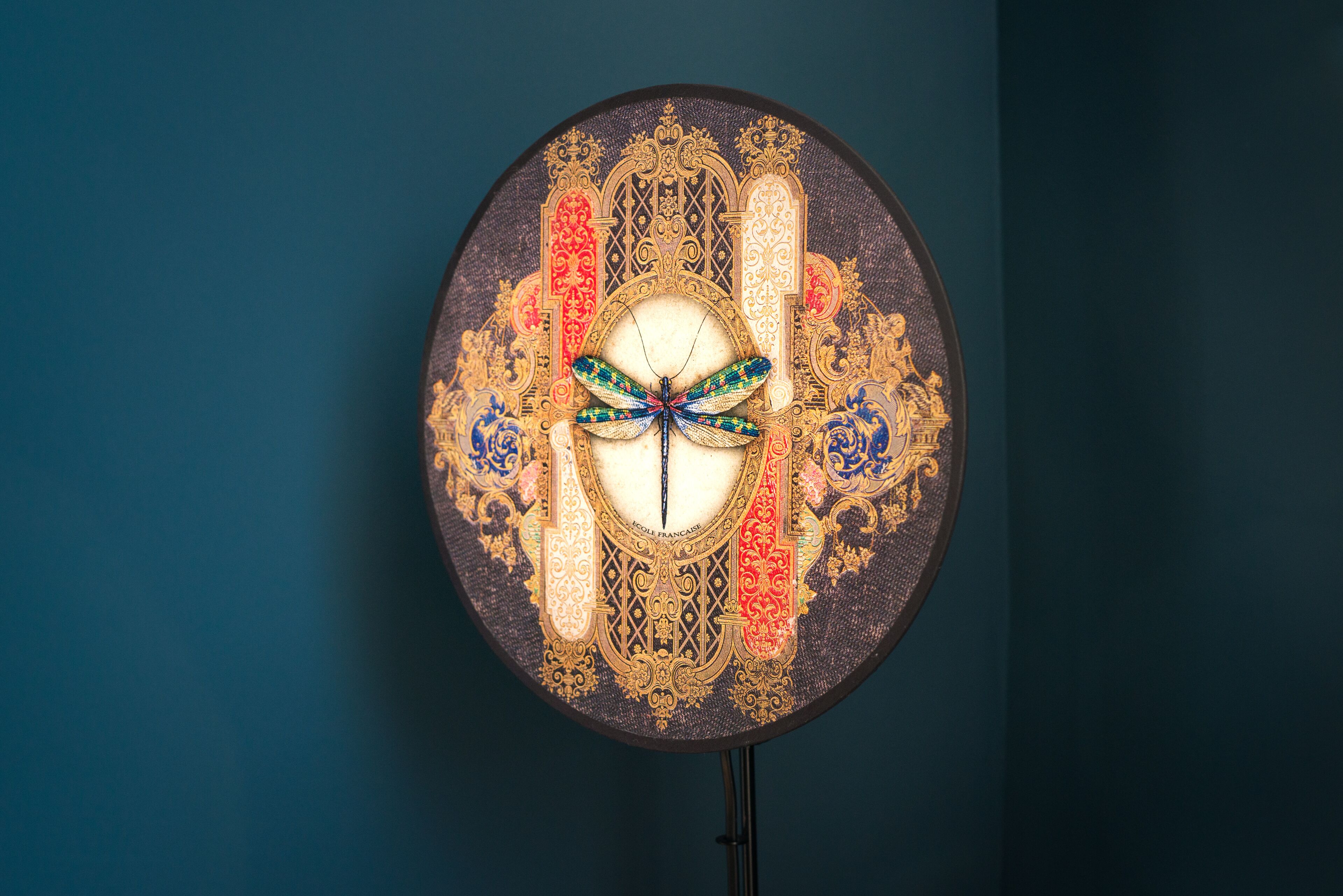 A circular, ornate clock with intricate designs and a central butterfly motif.