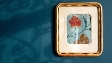 A framed artwork with a floral design on a blue background.