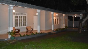 Un edificio con un porche cubierto, columnas blancas y techo de tejas.