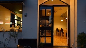 A building entrance with a glass door, a small porch, and a signboard outside. - SAGA International Guesthouse HAGAKURE - Hostel (Saga)