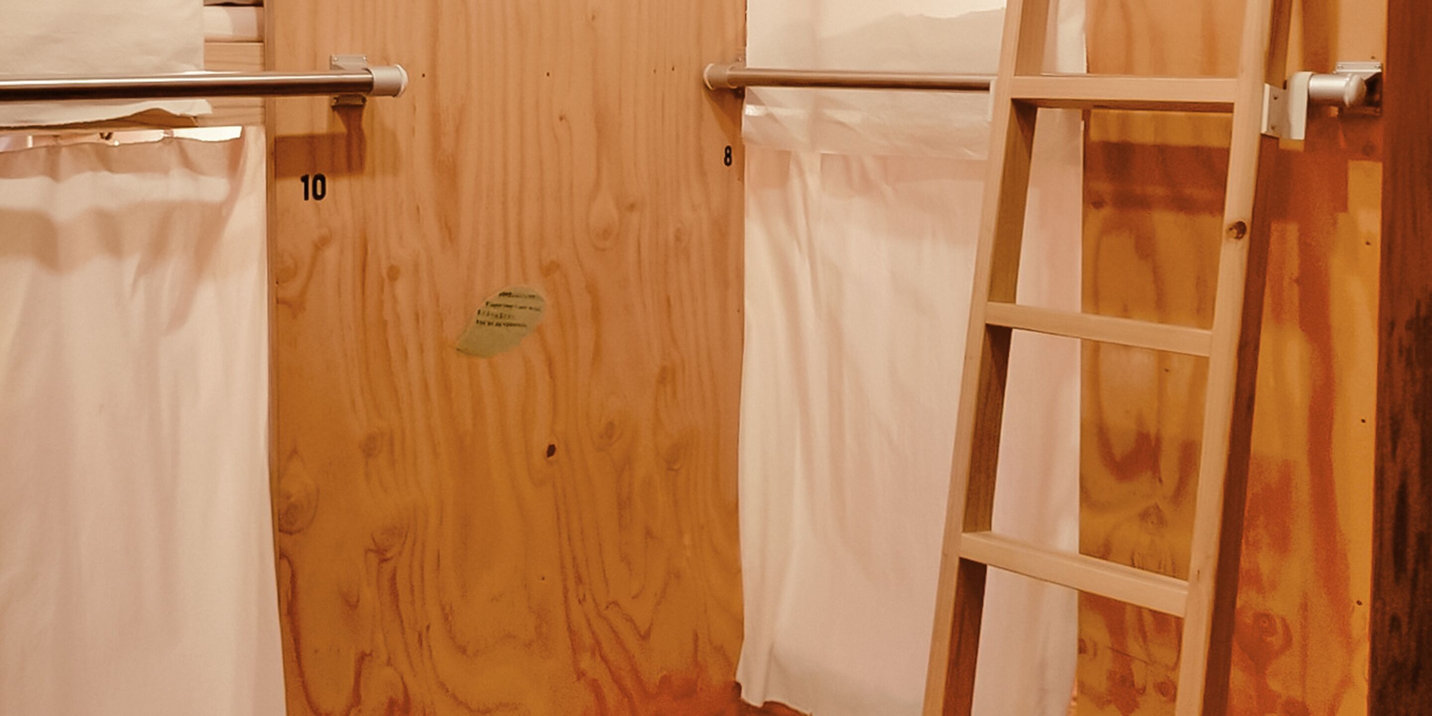 A wooden door with a towel rack and a ladder.