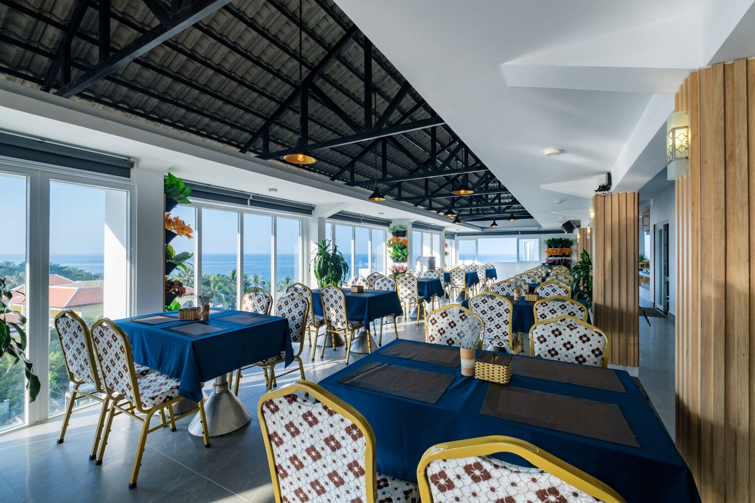 A spacious dining area with high ceilings and large windows overlooking a scenic view.