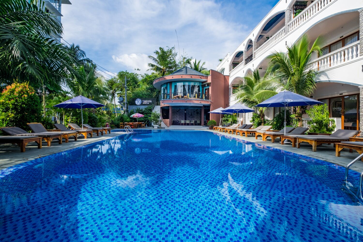 Een buitenzwembad, ligstoelen bij het zwembad