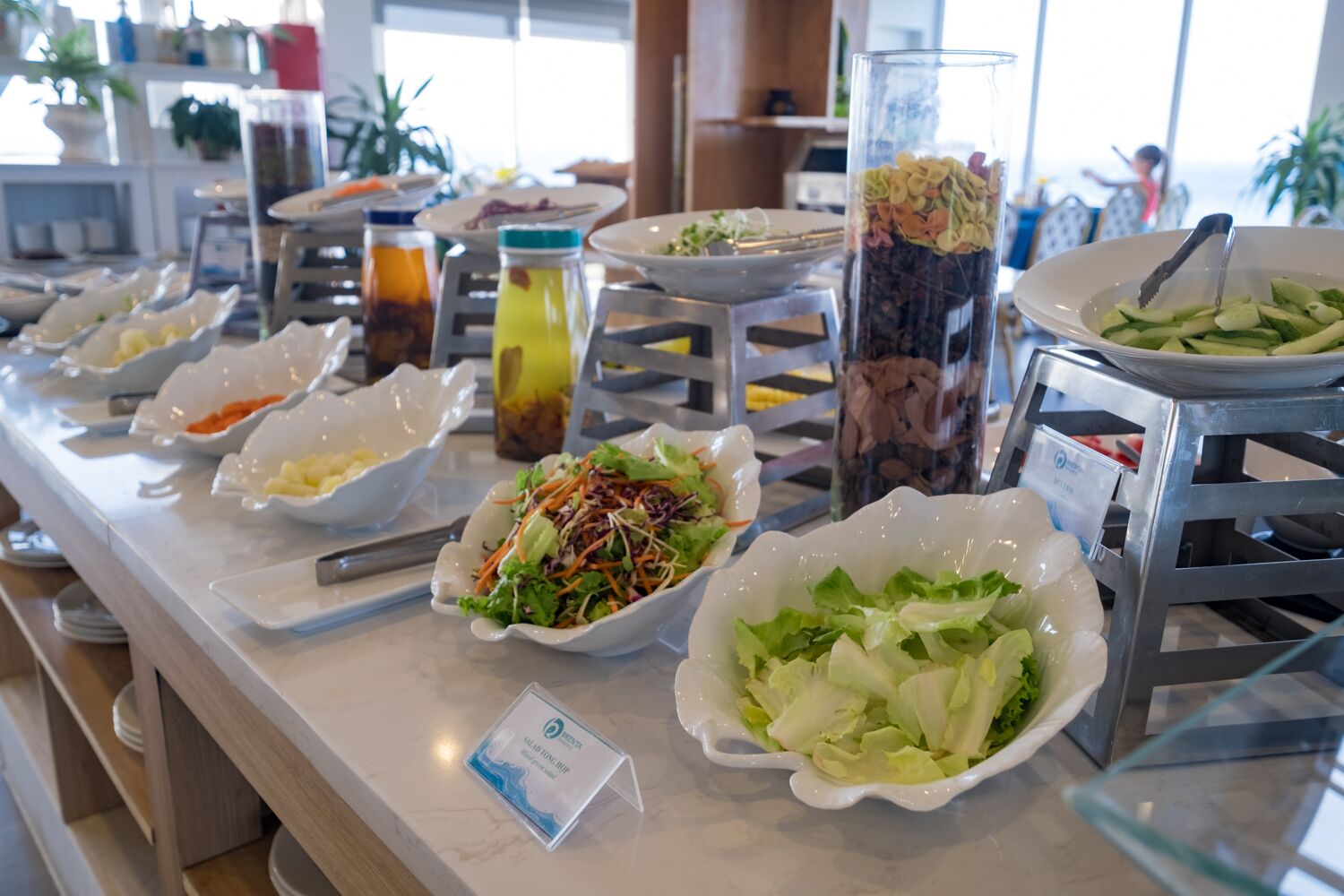 A buffet with various dishes including salads, fruits, and beverages.