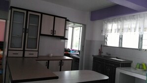 Eine Küche mit Schränken, einer Arbeitsplatte und einem Fenster mit Vorhängen.
