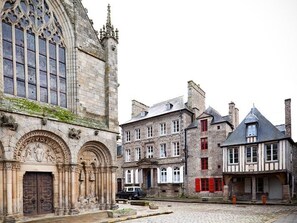 A historic building with a large arched entrance and a courtyard. - La Maison Pavie (Dinan)