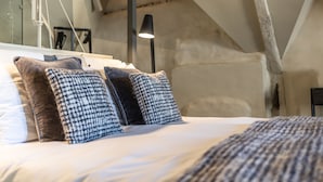 Une chambre à coucher avec un lit, des oreillers et une lampe.