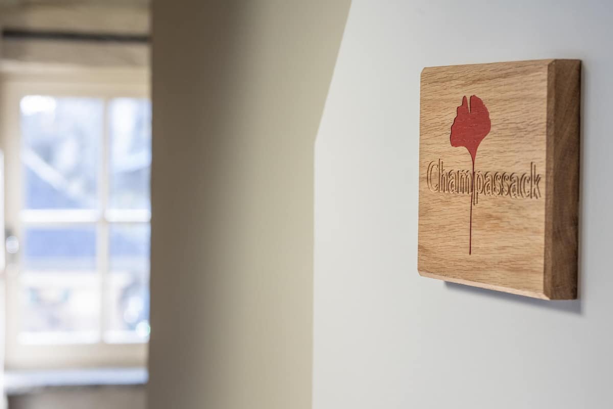 A wooden plaque with the word "Champassack" and a silhouette of a wine glass.