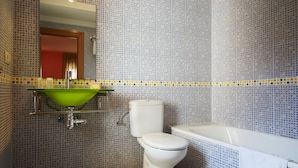 Une salle de bain avec un lavabo vert, des toilettes blanches et une baignoire.