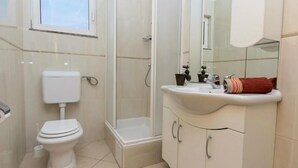 Un baño con inodoro, ducha y lavamanos.