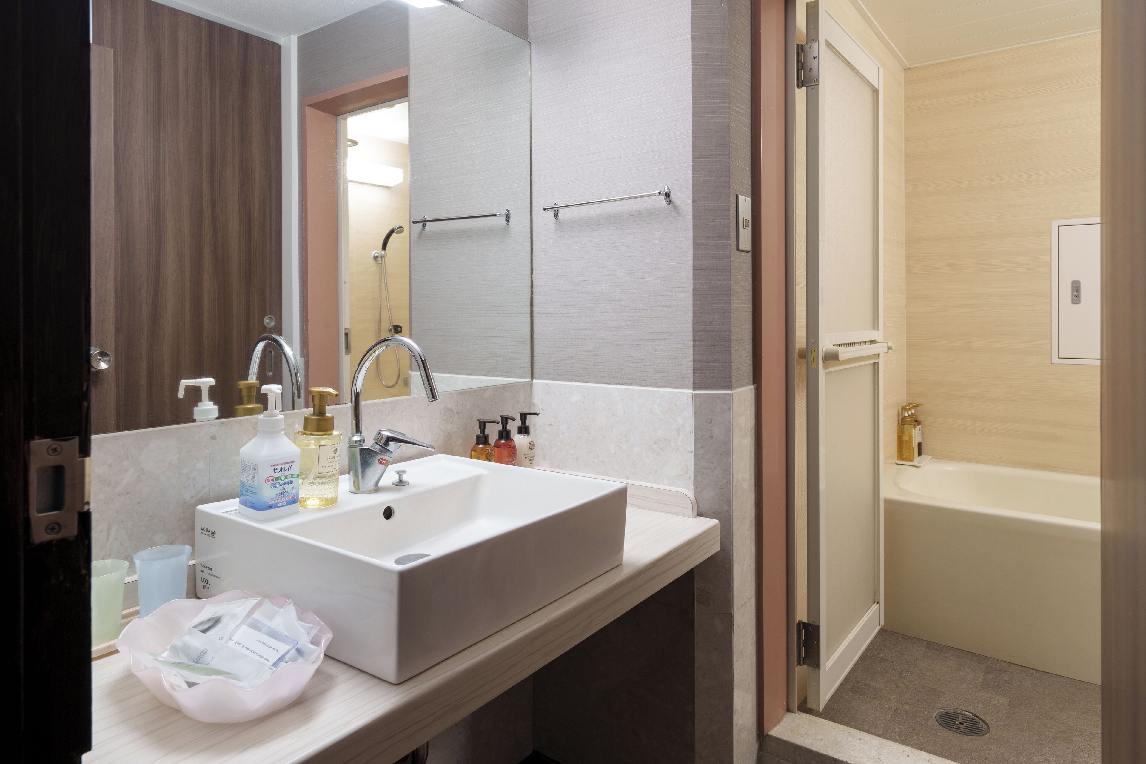 A modern bathroom with a white sink, mirror, and shower.