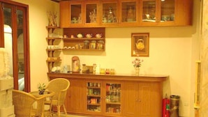 Una cocina con armarios de madera, un comedor con sillas de mimbre y una pequeña mesa.
